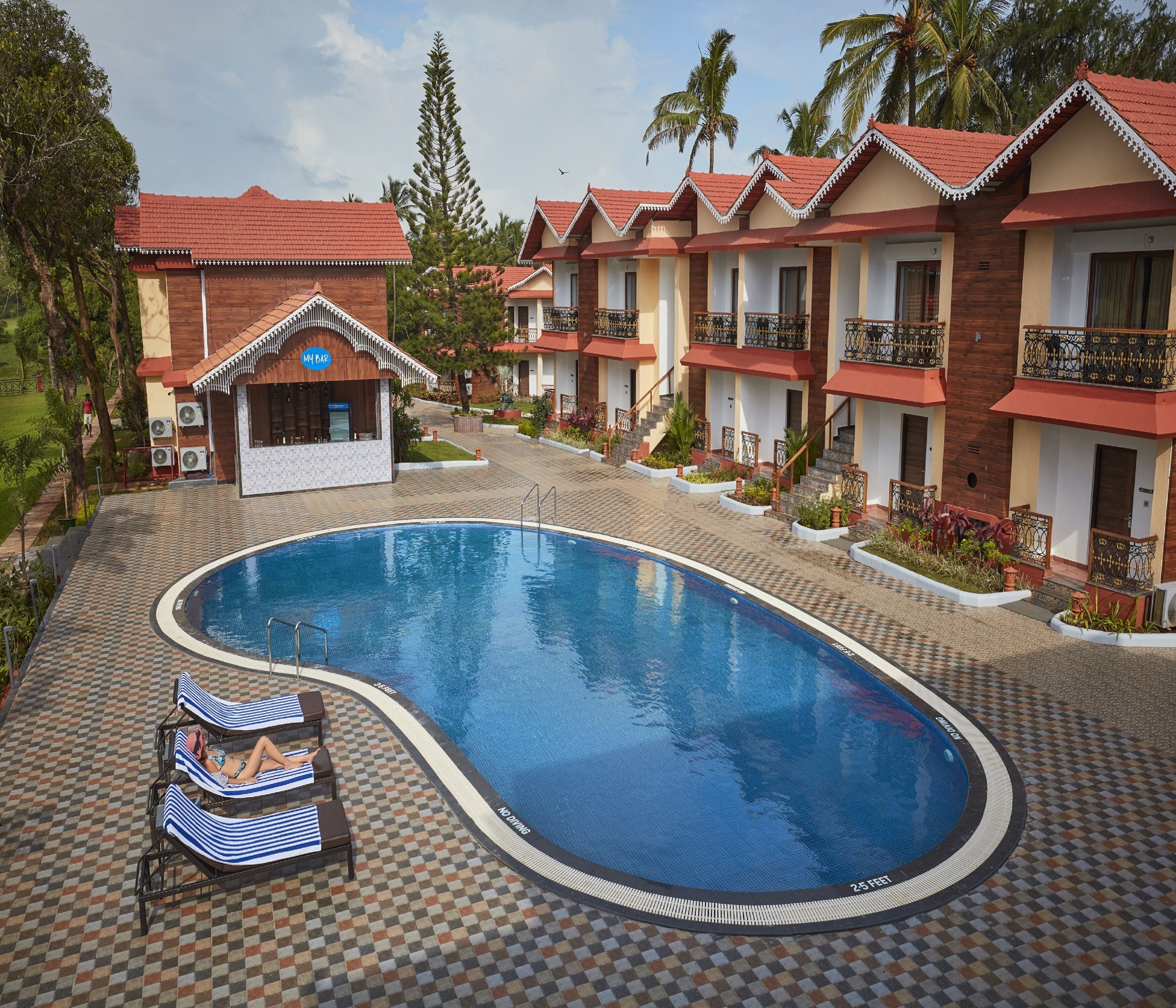 Een buitenzwembad, parasols bij het zwembad en ligstoelen