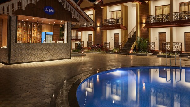 Un hotel con un bar llamado "MUBAR" y una piscina.
