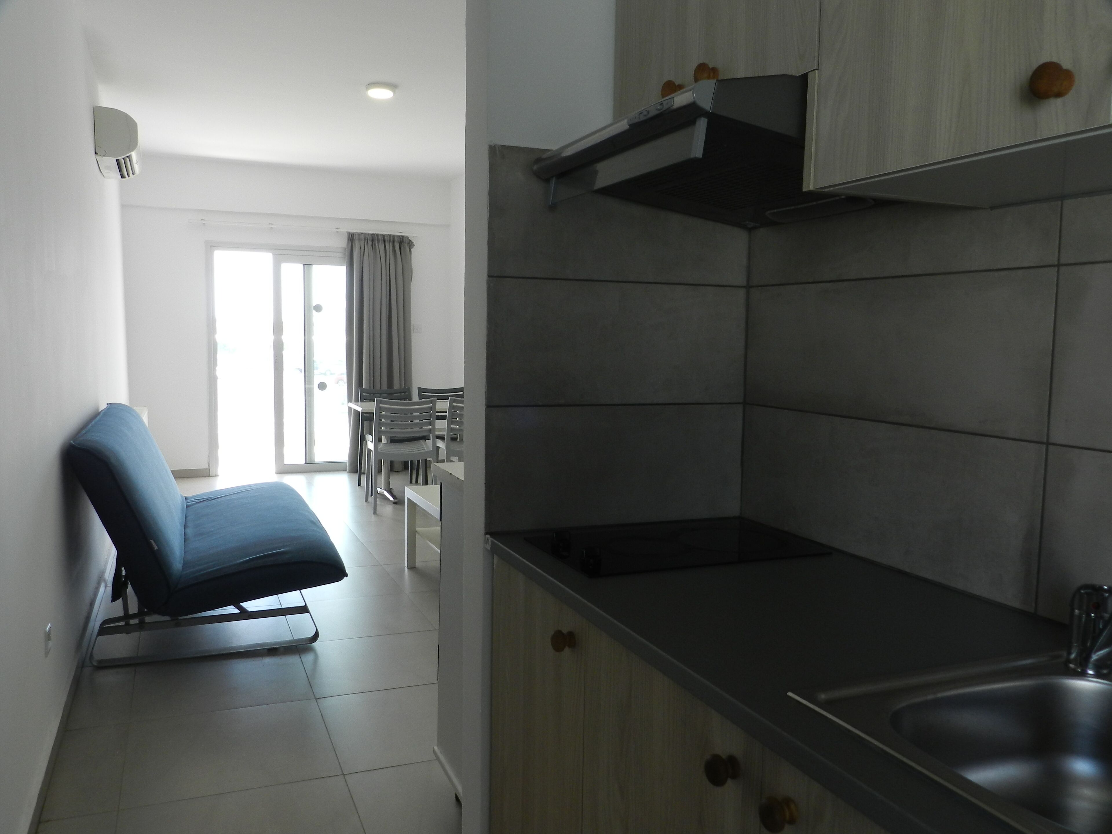 Une cuisine moderne équipée d’une cuisinière intégrée, d’un évier et d’un coin repas avec une table et des chaises.