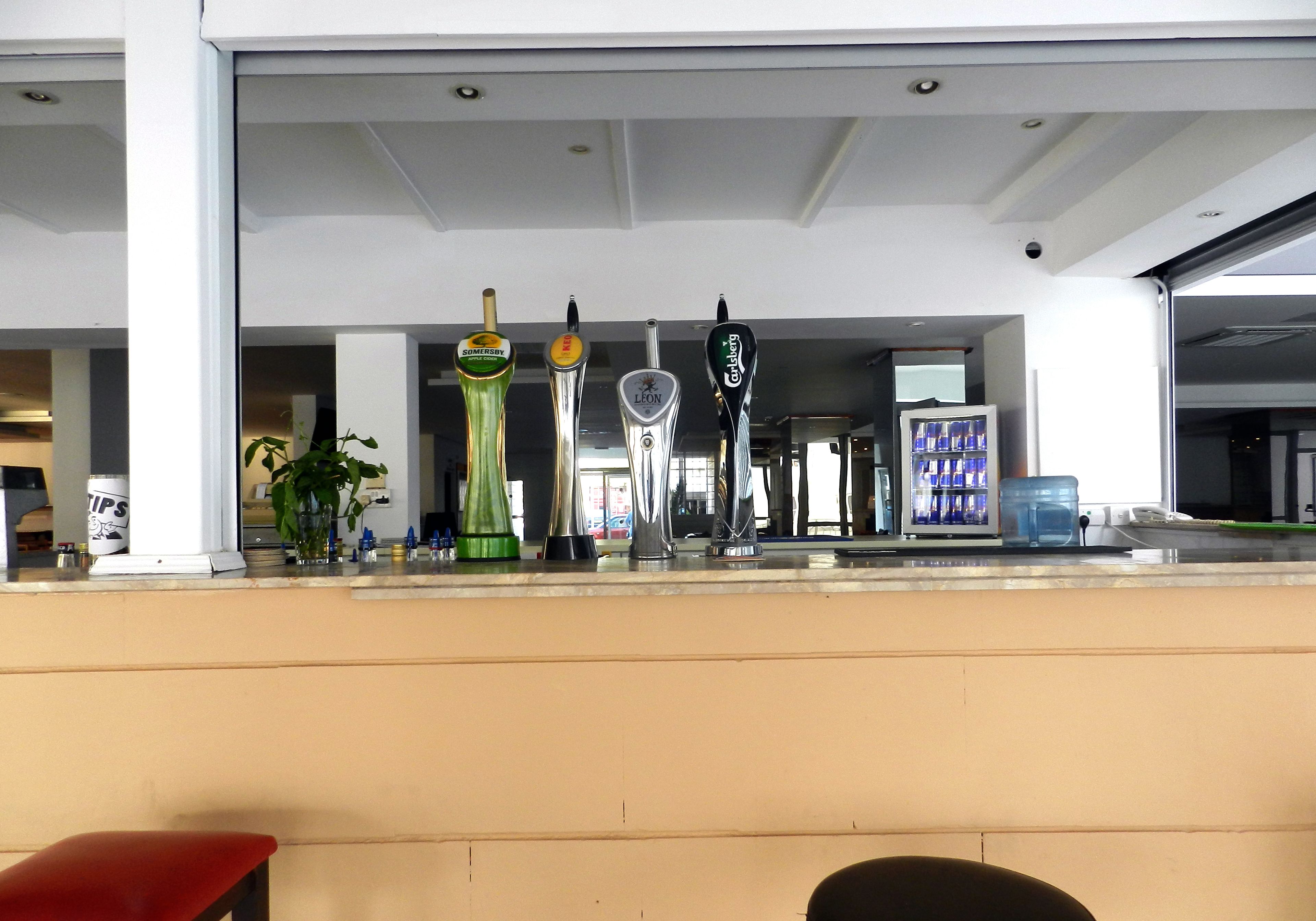 A bar area with multiple beer taps, a counter, and seating.