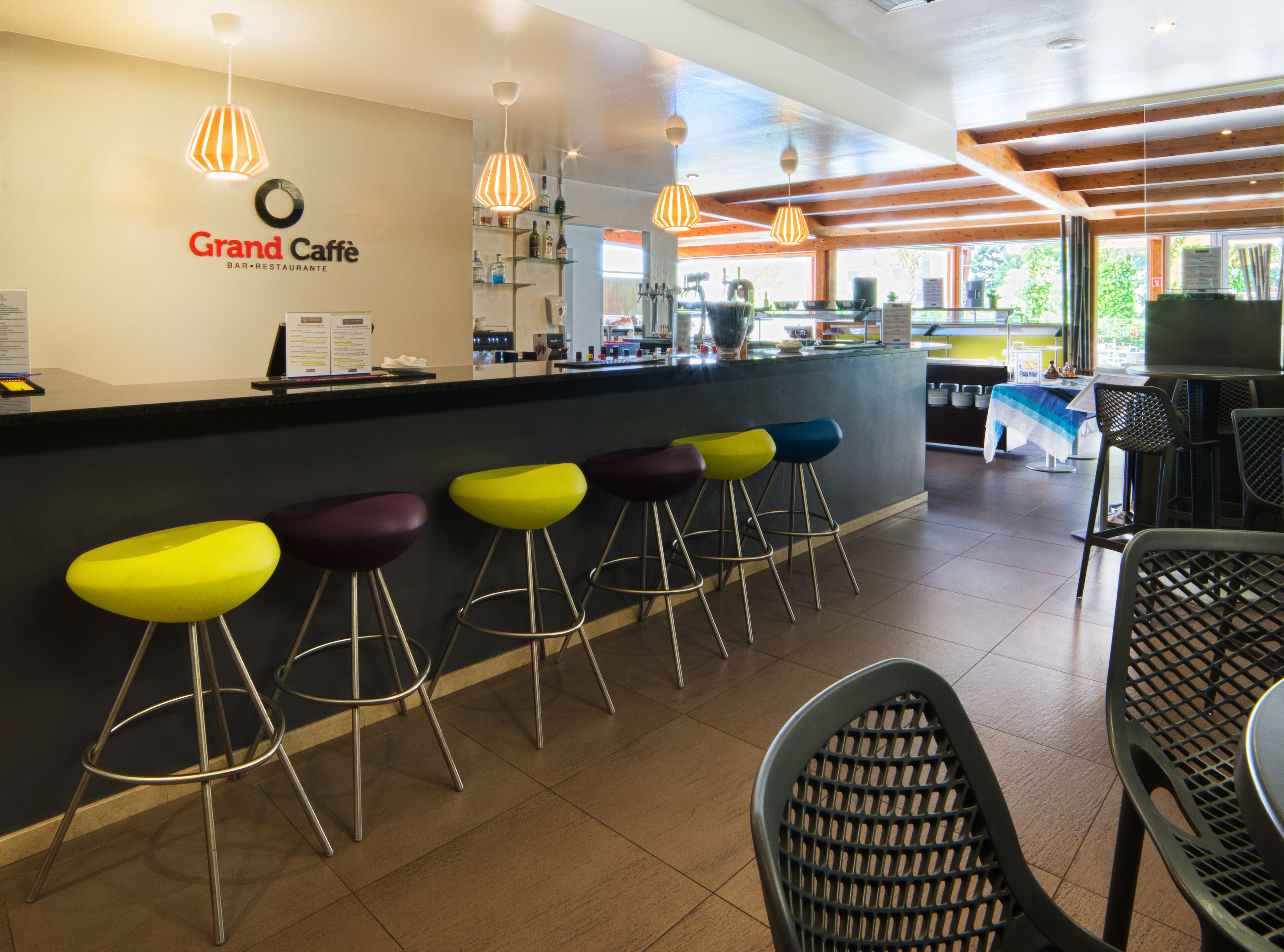 A bar area with a counter, stools, and a menu board.