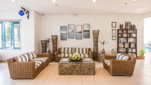 A spacious living room with a large sofa set, a coffee table, and a bookshelf.