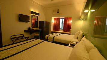 A hotel room with two beds, a TV, a desk, and a window with curtains.