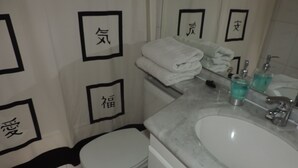 Een bad/douchecombinatie, een diep bad, designer toiletartikelen