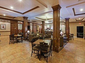 A hotel lobby with a dining area, sofas, and a bar. - Holiday Inn Express Hotel & Suites Houston-Alvin by IHG (Alvin)