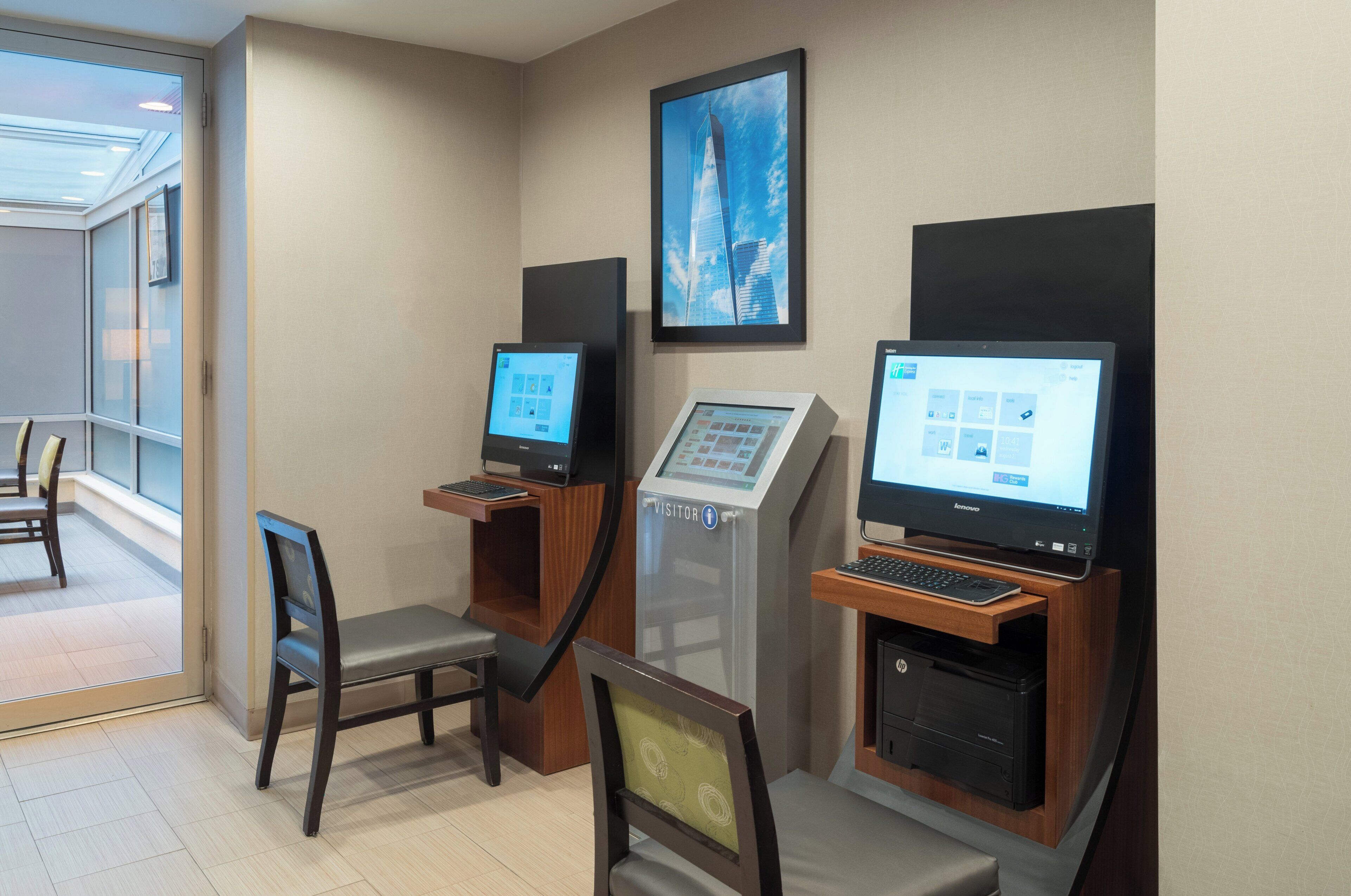 Een hotel lobby met een receptiebalie, een stoel, een computer en een printer.