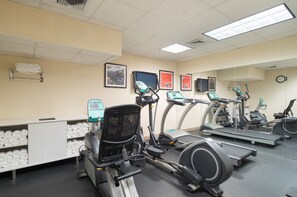 A gym with exercise equipment, a towel rack, and framed pictures on the wall. - Holiday Inn Express New York City- Wall Street by IHG (New York)