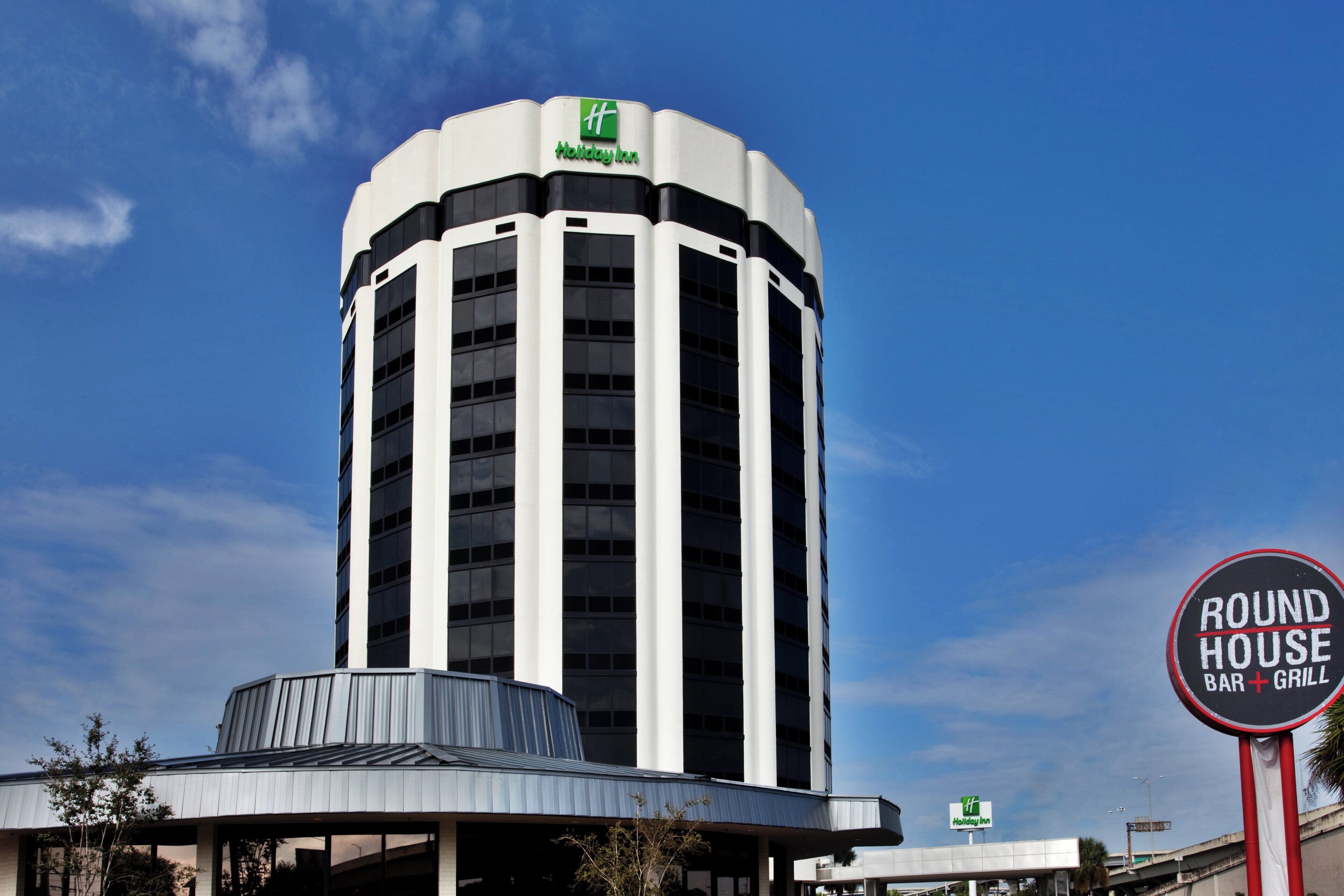 Un hotel Holiday Inn con una torre cilíndrica distintiva y una estructura de techo plano en la base.