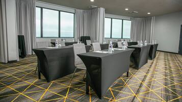 A conference room with tables, chairs, and water bottles.