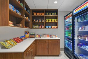 A snack and beverage section with shelves stocked with various snacks and a refrigerated display case. - Holiday Inn Express Atmore by IHG (Atmore)