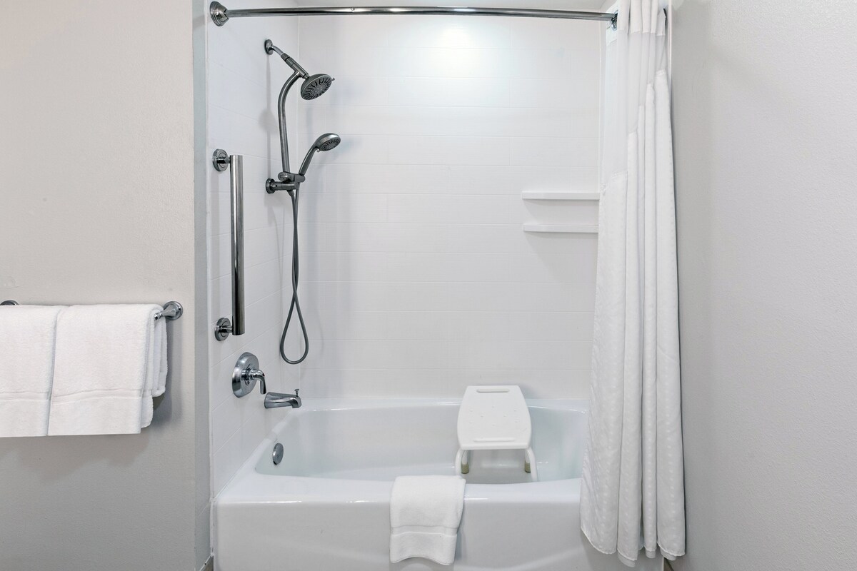 A modern bathroom with a walk-in shower, a bathtub, and a toilet.
