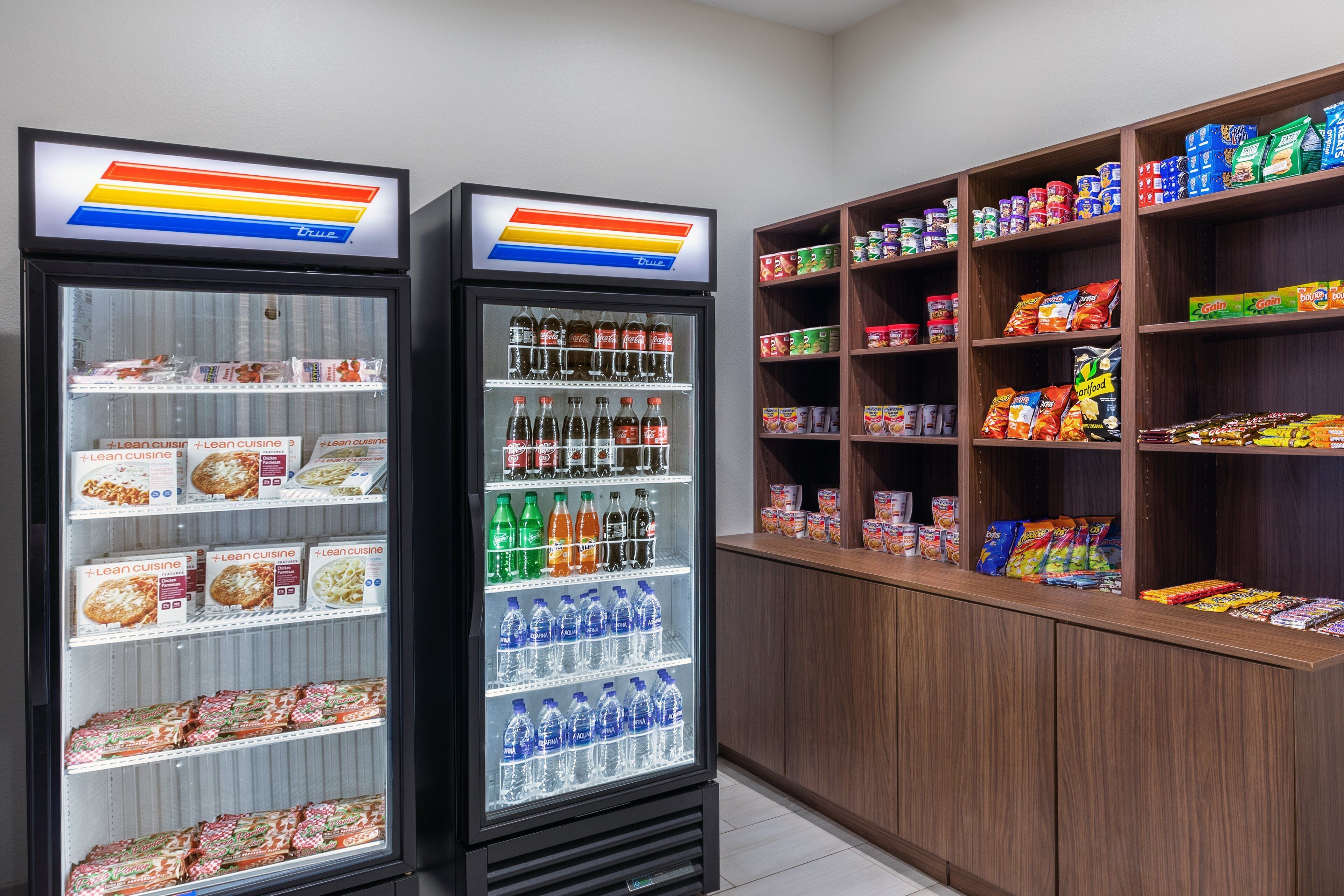 Two beverage dispensers stocked with various drinks and snacks.