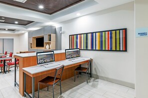 A modern business center with desks, chairs, and a colorful striped artwork on the wall.