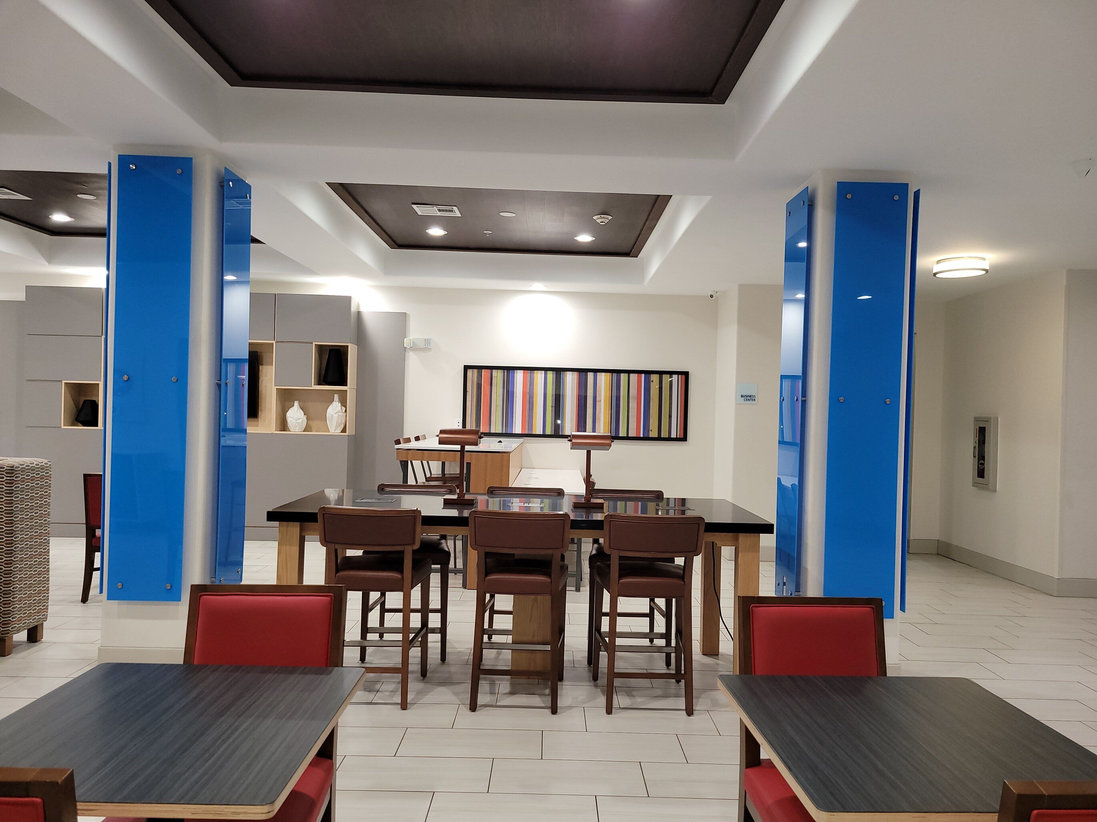 Un comedor moderno con una mesa central, sillas e iluminación empotrada en el techo.