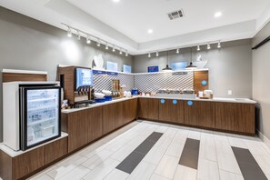 A modern kitchen with wooden cabinets, a refrigerator, and a countertop with various items. - Holiday Inn Express Hotel & Suites VIDOR SOUTH by IHG (Vidor)