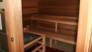 A sauna with wooden benches and a bench with a towel rack.