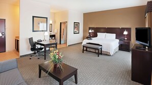A hotel room with a bed, a desk, a chair, a television, and a sofa. - Hampton Inn and Suites Dumas (Dumas)