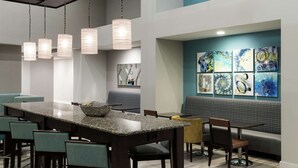 A modern interior with a long bar area, seating, and artwork on the walls. - Hampton Inn & Suites Panama City Beach-Pier Park Area (Panama City Beach)
