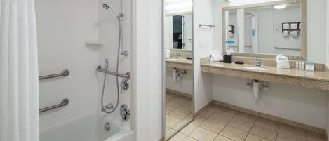 A modern bathroom with a walk-in shower, a bathtub, a vanity with a mirror, and a toilet.