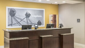A reception desk with two computers, a phone, and a framed picture of a Ferris wheel. - Hampton Inn & Suites Panama City Beach-Pier Park Area (Panama City Beach)