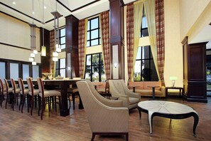 A spacious dining area with high ceilings, large windows, and a mix of dining and seating arrangements.