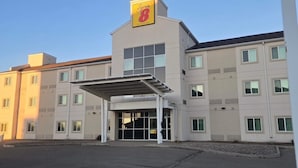 Un hotel con un llamativo letrero 'Sypes 8', un acceso cubierto y varias ventanas.