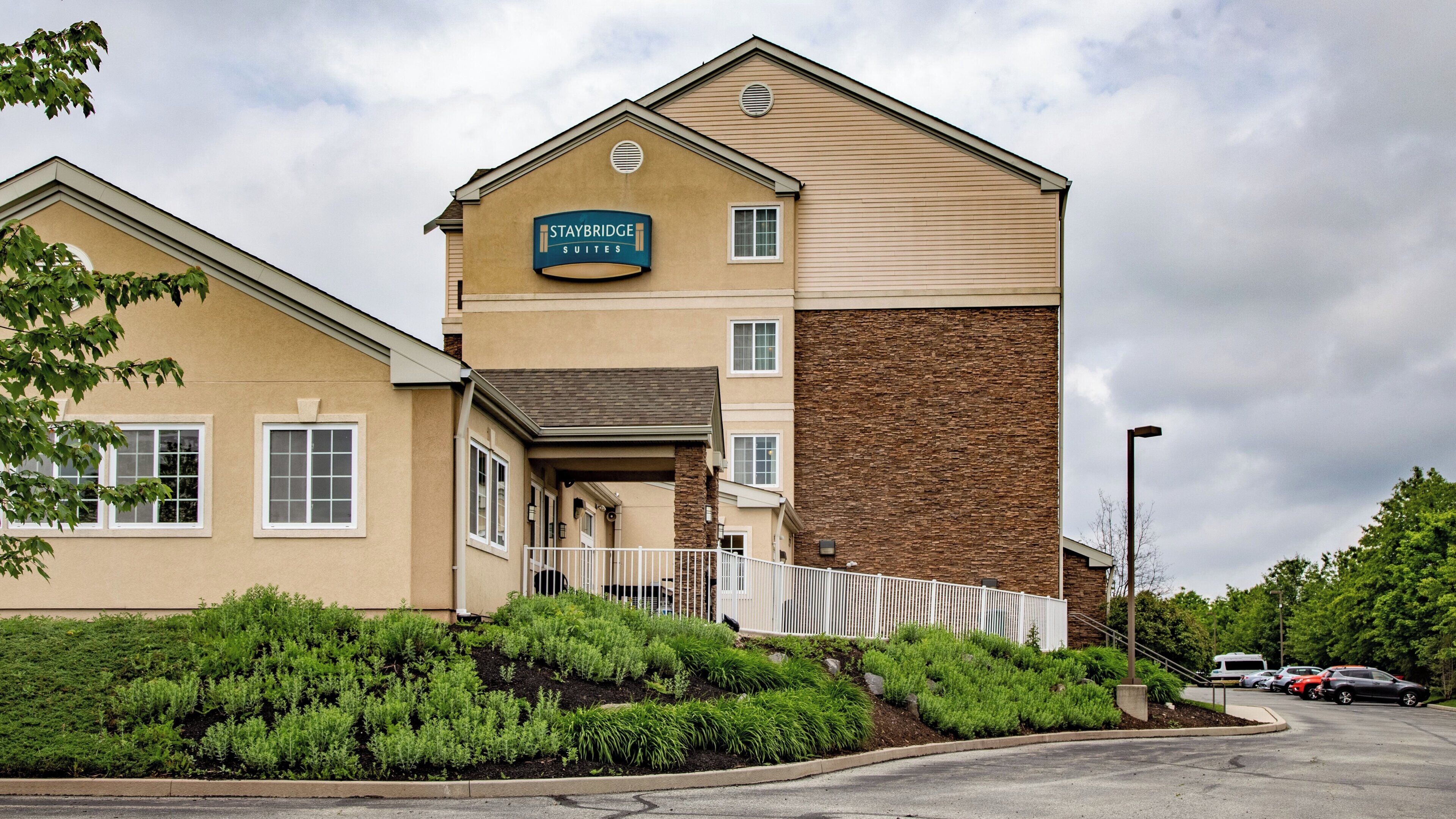 A Staybridge Suites hotel with a two-story building, a covered entrance, and a parking lot.