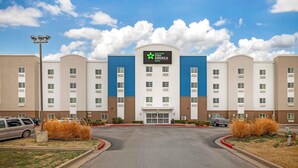 A hotel with a central entrance, multiple floors, and a blue and white color scheme.