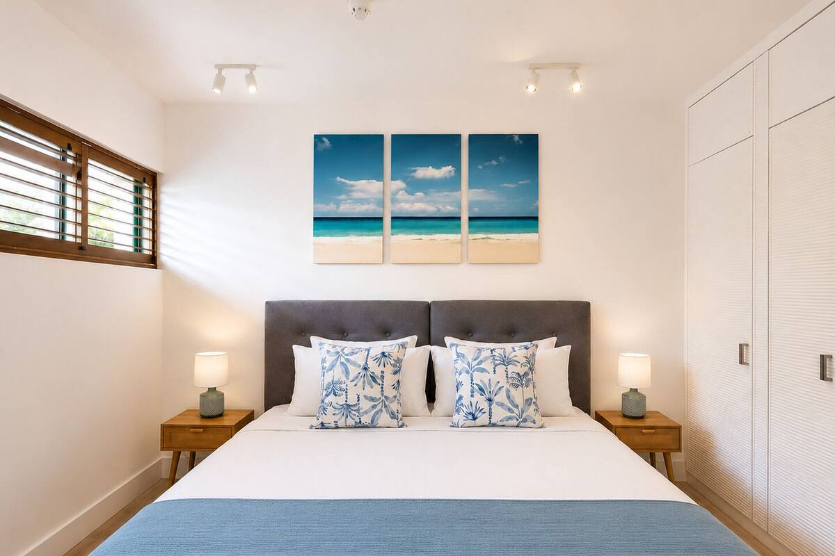 A bedroom with a bed, two nightstands, a wardrobe, and a window with blinds.