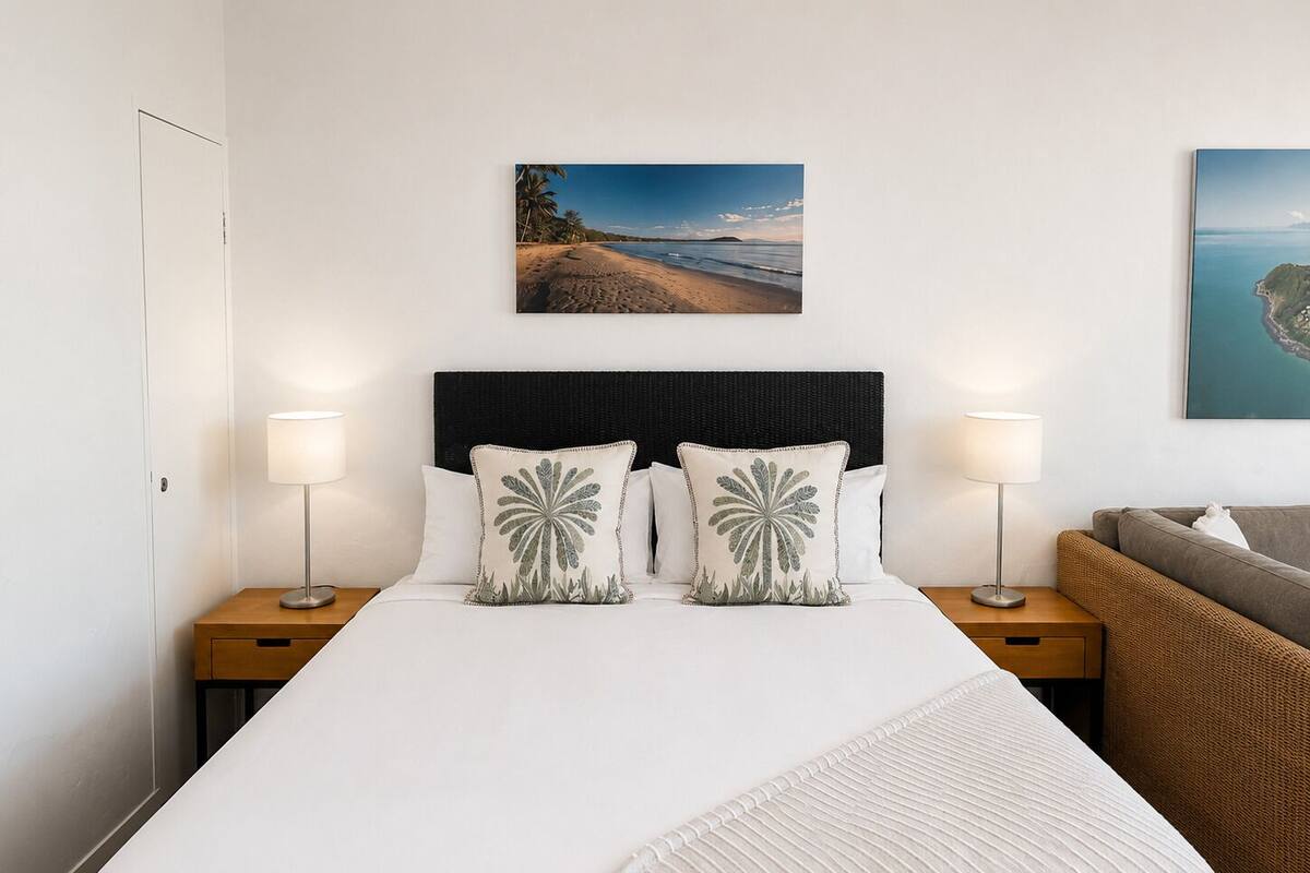 A hotel room with a bed, two nightstands, a headboard, and two wall-mounted lamps.