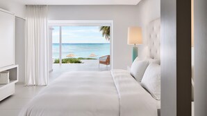 Une chambre d’hôtel avec un grand lit, une télévision, une lampe et une vue sur l’océan.