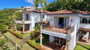 A two-story house with a balcony, a garden, and a view of the surrounding area. - Bahia del Sol Villas & Condominiums (San Juan del Sur)