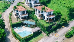A residential area with multiple two-story houses, a swimming pool, and a thatched-roof structure. - Bahia del Sol Villas & Condominiums (San Juan del Sur)