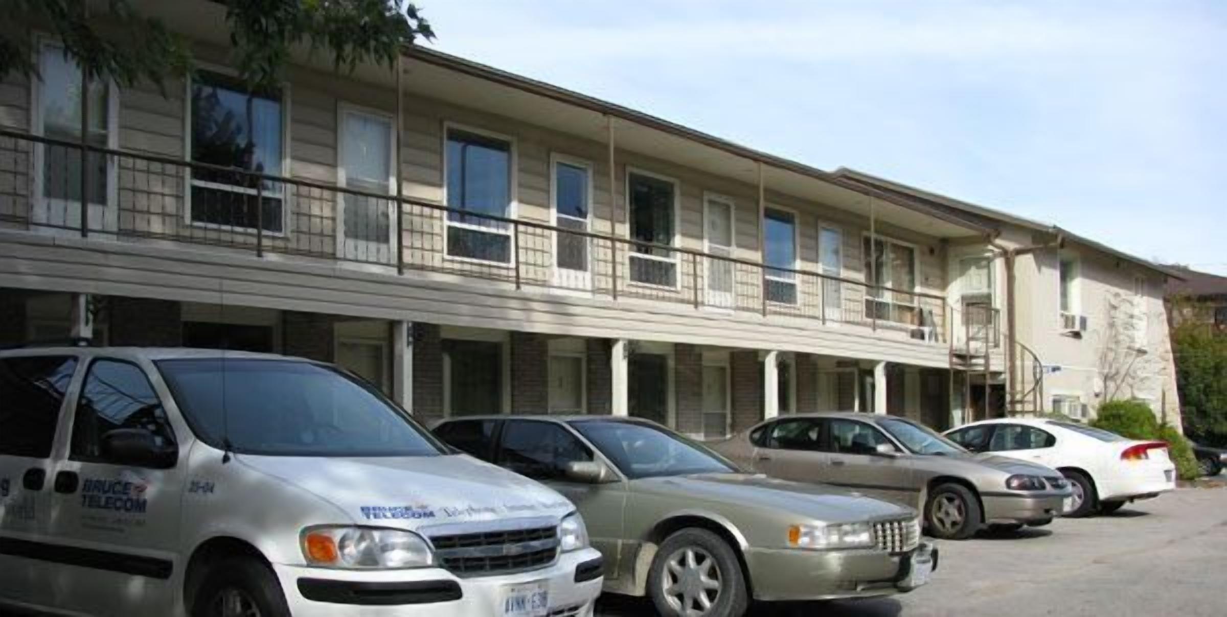 A row of single-story buildings with multiple windows and balconies.