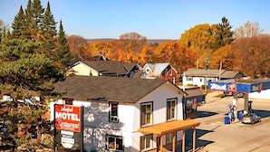 Un motel con un cartel que indica habitaciones disponibles, una estación de servicio y un pequeño edificio con un letrero de restaurante.