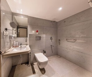 A modern bathroom with a toilet, sink, and shower.