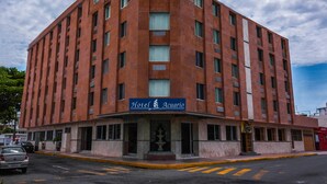 Un hotel de varios pisos con una entrada destacada y un cartel que dice "Hotel Acuario".