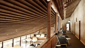 A long corridor with wooden beams, seating areas, and large windows. - Comwell Klarskovgaard (Korsor)