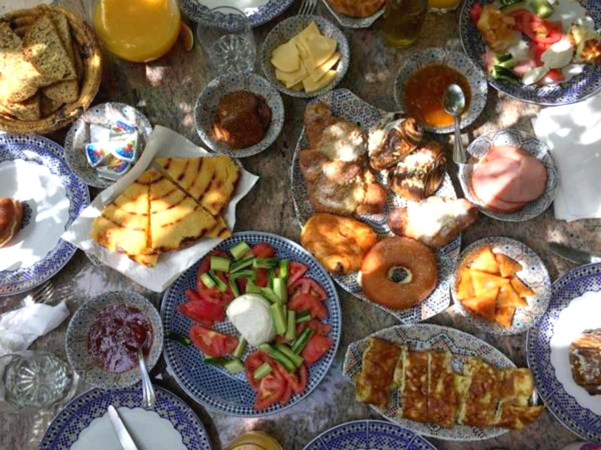 Una mesa con varios platos, incluyendo pan, ensaladas y una tarta de frutas.