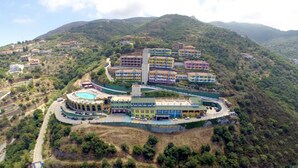 A hotel with multiple buildings, a swimming pool, and a curved road.