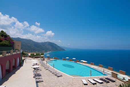 Outdoor pool, pool umbrellas, sun loungers. Hotel Avalon Sikanì