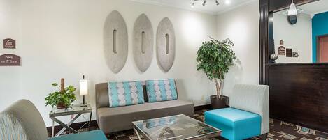 A modern living room with a sofa, armchairs, a coffee table, and decorative wall art.