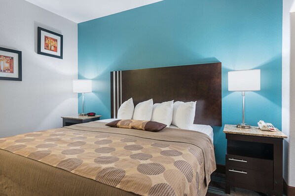 A hotel room with a large bed, two bedside tables with lamps, a headboard, and framed pictures on the wall. - Best Western Plus Deridder Inn & Suites (DeRidder)
