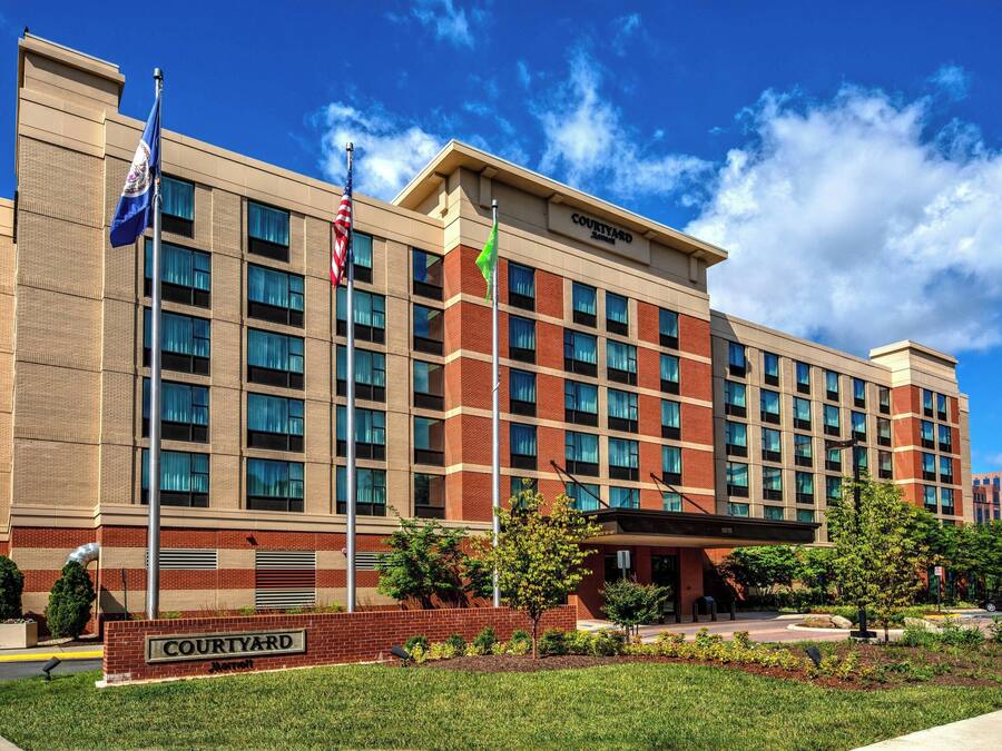 Ett Courtyard Marriott-hotell med en fasad av tegel, många fönster och ett välordnat entréområde.