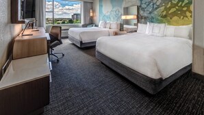 A hotel room with two beds, a desk, a chair, a TV, and a large window with a city view. - Courtyard by Marriott Dulles Airport Herndon (Herndon)
