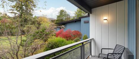 A covered outdoor area with a wooden deck, two chairs, and a table.