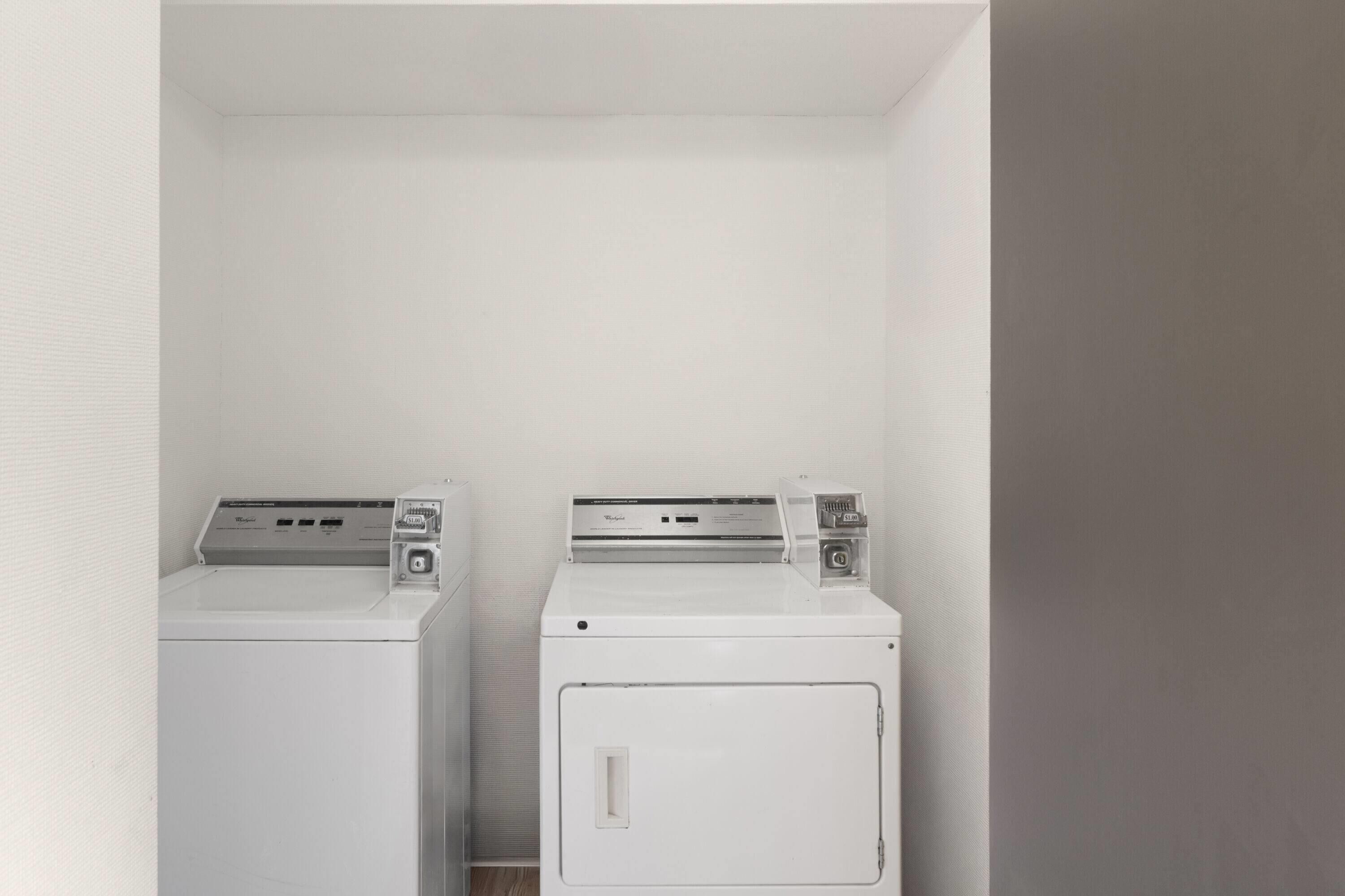 Une buanderie équipée de deux machines à laver blanches.