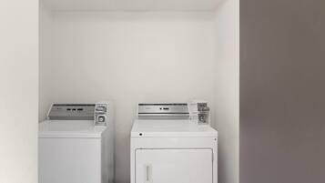 Une buanderie équipée de deux machines à laver blanches.