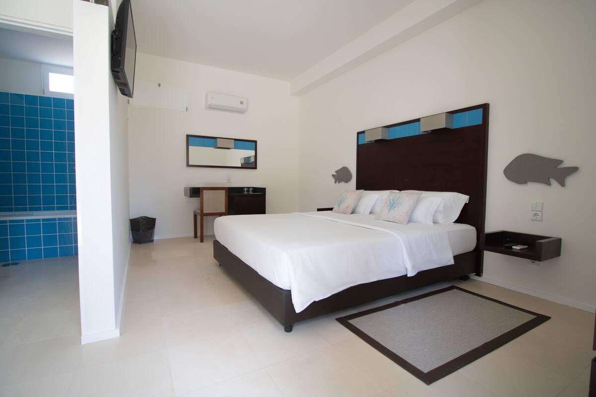 A bedroom with a bed, bedside table, and a small desk.