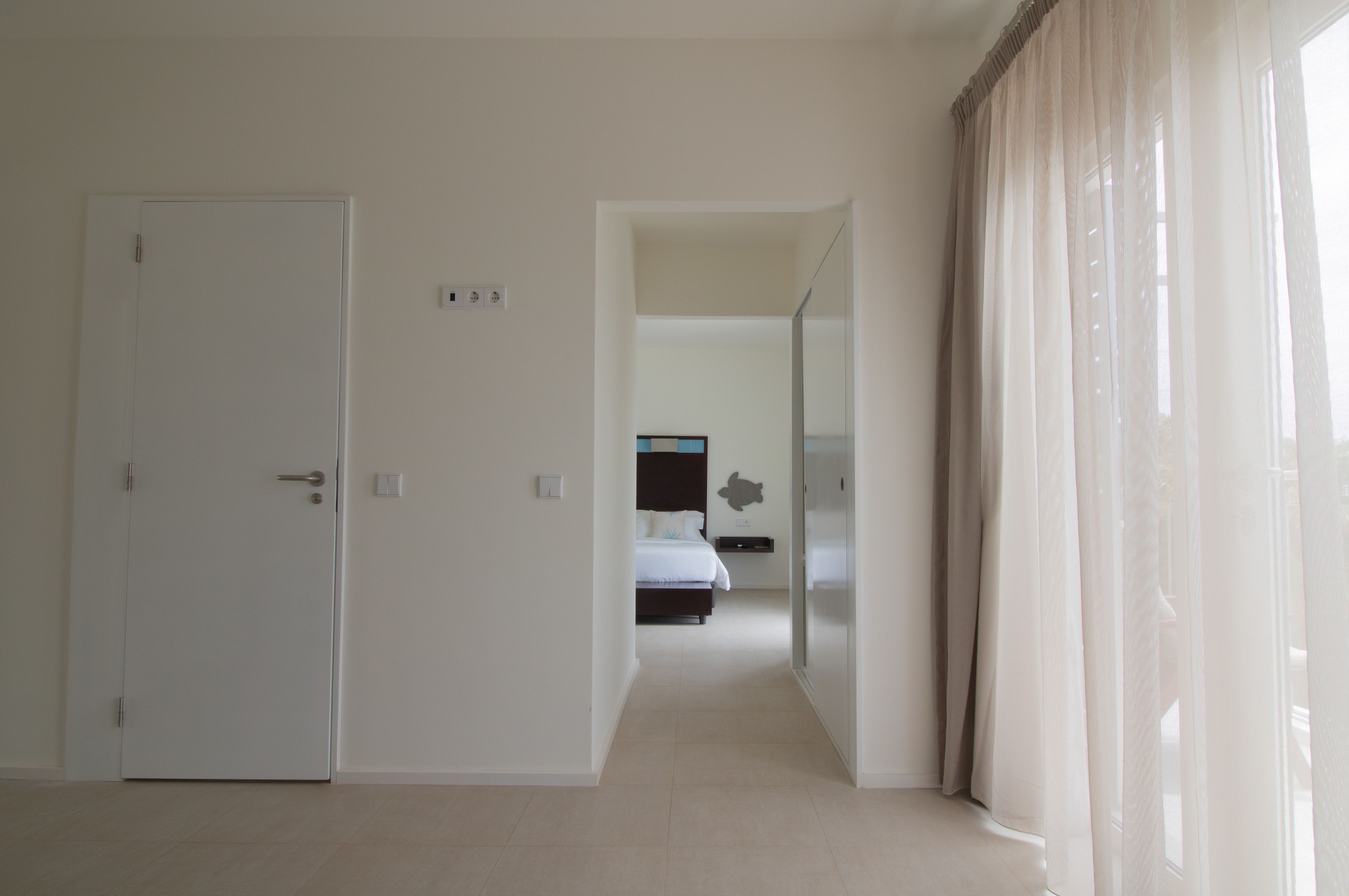 A hotel room with a bed, a wardrobe, and a mirror.